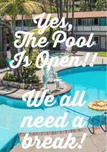 a sign that reads we the pool is open we all need a meal at Kings Inn in San Diego