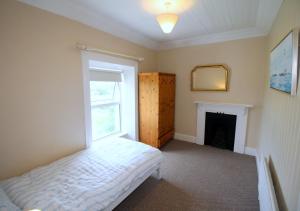 a bedroom with a bed and a window and a mirror at Alcorn's Farmhouse in Rathmullan