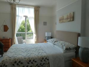 a bedroom with a bed and a large window at Bron Aber in Criccieth