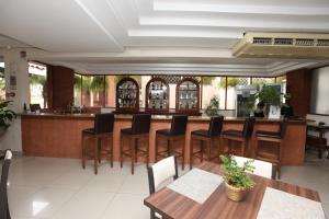 ein Restaurant mit einer Bar mit Holztischen und -stühlen in der Unterkunft IPÊ PARK Convention Hotel in Sao Jose do Rio Preto