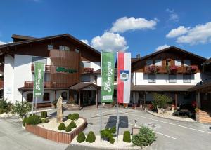 budynek z dwoma flagami przed nim w obiekcie Hotel Königgut w mieście Wals-Siezenheim