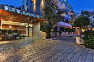Hotel Harmony by Aycon في بتروفاتس نا مورو: ممر للفندق به طاولات وكراسي امام مبنى