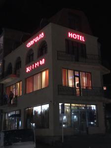 un hotel con letreros de neón en su costado en Flamenco Hotel, en Sisian