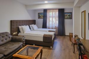 a hotel room with a bed and a couch at Hotel Splendid in Pleven