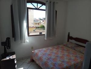 a bedroom with a bed and a window at Casa de praia; Itapebussu, Guarapari, ES. in Guarapari