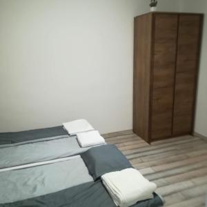 オロシュハーザにあるGolden Apartmanのベッドルーム1室(ベッド1台付)、木製キャビネットが備わります。