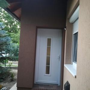a white door on the side of a house at Golden Apartman in Orosháza