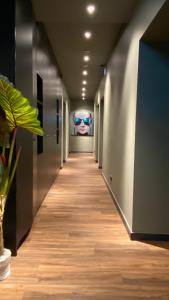 a long hallway with a room with a person wearing sunglasses at Munich Rooms Hotel in Munich