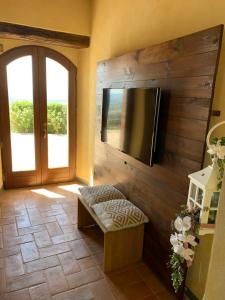a living room with a flat screen tv and a bench at Domus Clara in Assisi