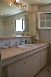 a bathroom with a sink and a mirror at Theros Villa in Plános +29 photos