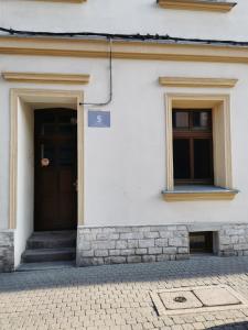 een wit gebouw met een deur en twee ramen bij Gliwicka 5 w samym sercu Tarnowskich Gór in Tarnowskie Góry