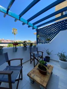 a patio with chairs and a table on a roof at Retro n’ Boujee 1BR Apt with Pool and Balcony in Yeroskipou