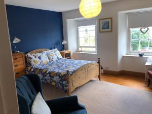 a bedroom with a bed and a blue wall at 3 Bedroom 2 Bathrooms Apartment in Central Penzance in Penzance