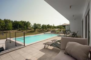 a house with a swimming pool and a couch at Infinity pool Villa San Amore in Divšići