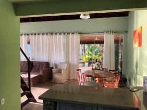 a living room with a table and a couch at Chalé da Clarissinha in Mangaratiba