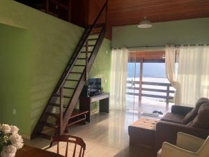 a living room with a staircase and a couch at Chalé da Clarissinha in Mangaratiba