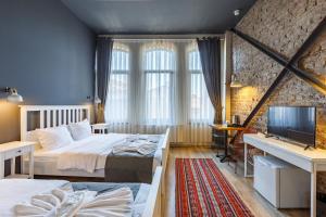 a bedroom with two beds and a flat screen tv at Hotel Miro Mansion Old City in Istanbul