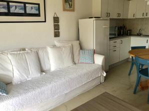 a living room with a white couch and a kitchen at Moulis in Hourtin