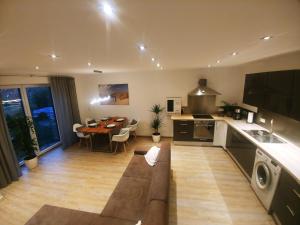 una cucina e un soggiorno con un tavolo e un divano di Ferienwohnung MIA-LENA a Penzing