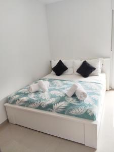 ein Schlafzimmer mit einem Bett mit einer blauen und weißen Decke in der Unterkunft White Studio Apartman in Pula