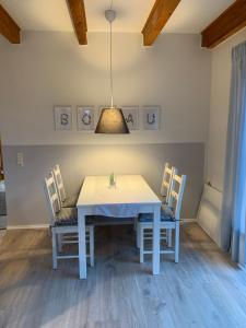 a dining room with a white table and chairs at Ferienhaus SüdWest in Bosau