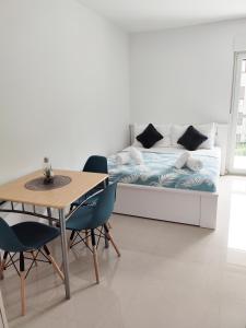 ein Schlafzimmer mit einem Bett und einem Tisch und Stühlen in der Unterkunft White Studio Apartman in Pula