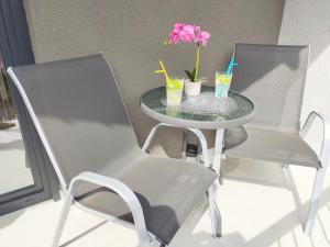 ein Tisch mit einem Stuhl und zwei Getränken darauf in der Unterkunft White Studio Apartman in Pula
