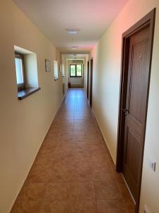 a hallway with a long hallway with a door and a tile floor at Pensiunea Casa Soarelui in Şimian