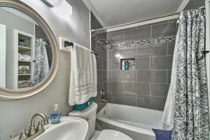 a bathroom with a tub and a sink and a mirror at Cozy San Antonio Family Home 3 Mi to Lackland AFB in San Antonio +16 photos
