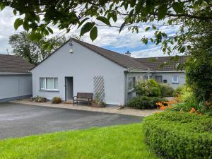 una casa blanca con un banco en un patio en Elagh View Bed & Breakfast en Derry