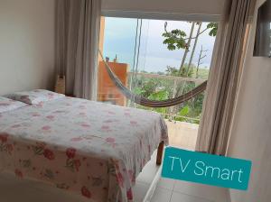 - une chambre avec un lit et une fenêtre avec vue dans l'établissement Chalé Sasaki Ilhabela, à Ilhabela