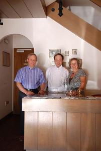 grupa trzech osób stojących za ladą w obiekcie Villa Luise w mieście Ortisei