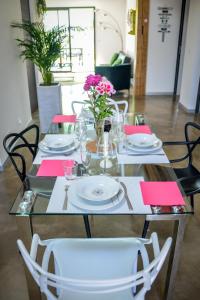 une table à manger avec des assiettes blanches et des serviettes roses dans l'établissement détente et confort - gite baie bocage, à Sartilly