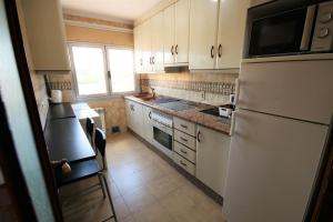 a kitchen with white cabinets and a white refrigerator at 380 Delicia de Teruel in Teruel