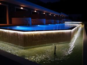 a swimming pool at night with a person in the water at Zoes Hotel & Suites in Faliraki