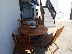 a wooden table and chairs on a patio with stairs at Vivenda Areias in Vila Nova