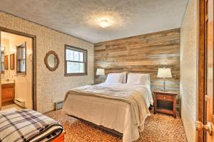 a bedroom with a bed and a wooden wall at Grand Lake Cabin Fireplace, 2 Mi to Grand Lake in Grand Lake