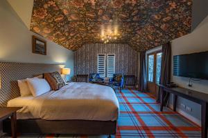 a bedroom with a bed and a ceiling decorated with flowers at The Dairy Private Hotel by Naumi Hotels in Queenstown