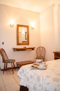 Zimmer mit einem Tisch, 2 Stühlen und einem Spiegel in der Unterkunft Esmeralda Palace Hotel in Buenos Aires
