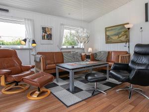 Fjand Gårdeにある6 person holiday home in Ulfborgのリビングルーム(革製家具、テーブル付)