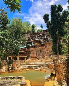a building on top of a hill with a pool of water at Paraiso Caño Hondo in Los Guineos Perdidos