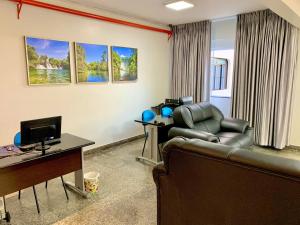 a living room with a couch and a television at Principe Hotel in Barreiras