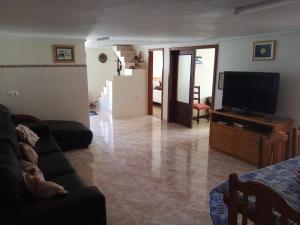 een woonkamer met een bank en een flatscreen-tv bij Vivenda Areias in Vila Nova