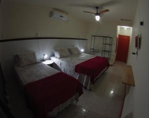 a hotel room with two beds and a fan at Pousada da Villa in Lençóis