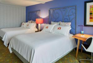 two beds in a room with blue walls at Inn at Northrup Station in Portland