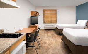 a hotel room with two beds and a desk and a kitchen at WoodSpring Suites Allentown Bethlehem in Bethlehem