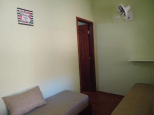 a small room with a bed and a door at Pousada Dona Esmeralda in São José do Barreiro