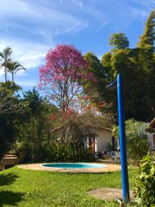 a blue pole in the grass with a tree at Hostel 040 in Itaipava