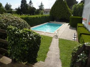 a patio with a pool and lawn furniture at Hôtel des Biches in Nuaillé