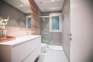 a bathroom with a white sink and a toilet at Liberty Suites by Santiago with AC in San Sebastián